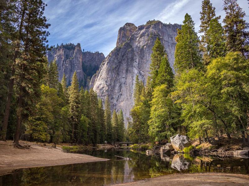 Granite cliffs rising above a pine forest and a still river